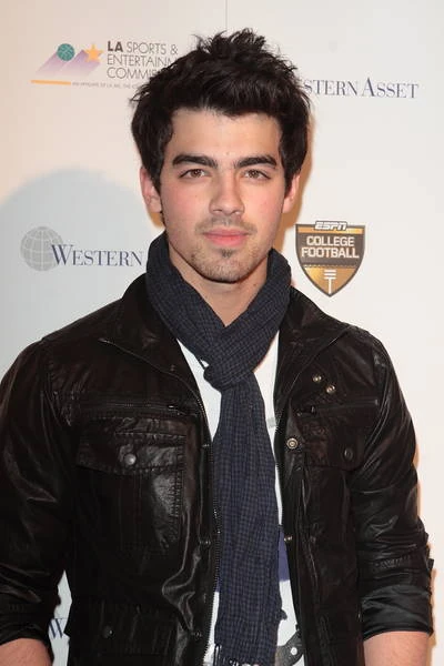 Joe Jonas (the last one to the left) surrounded by his brothers and Celine Dion