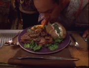 Steak with mushrooms sided with a baked potato topped with sour cream and chives.