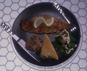 A dish of cooked catfish, with lemon